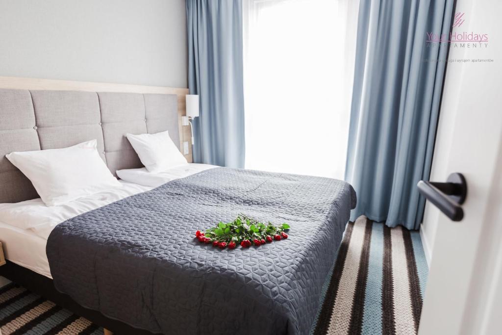 a hotel room with a bed with a flower arrangement on it at Your Holidays Bel Mare II in Międzyzdroje