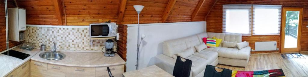 ein Wohnzimmer mit einem Sofa und einem TV in der Unterkunft Napsugár Vendégház Bükkszentkereszt in Bükkszentkereszt