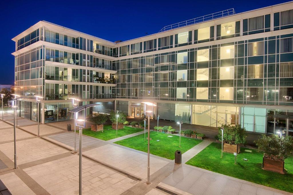 a large building with a courtyard in front of it at NH Savona Darsena in Savona