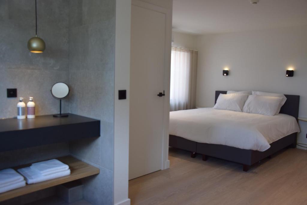 1 dormitorio con 1 cama y 1 mesa con toallas en B&B Villa Mimosa en Neerpelt