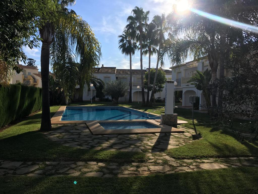 einen Pool in einem Garten mit Palmen in der Unterkunft Casa Denia in Denia