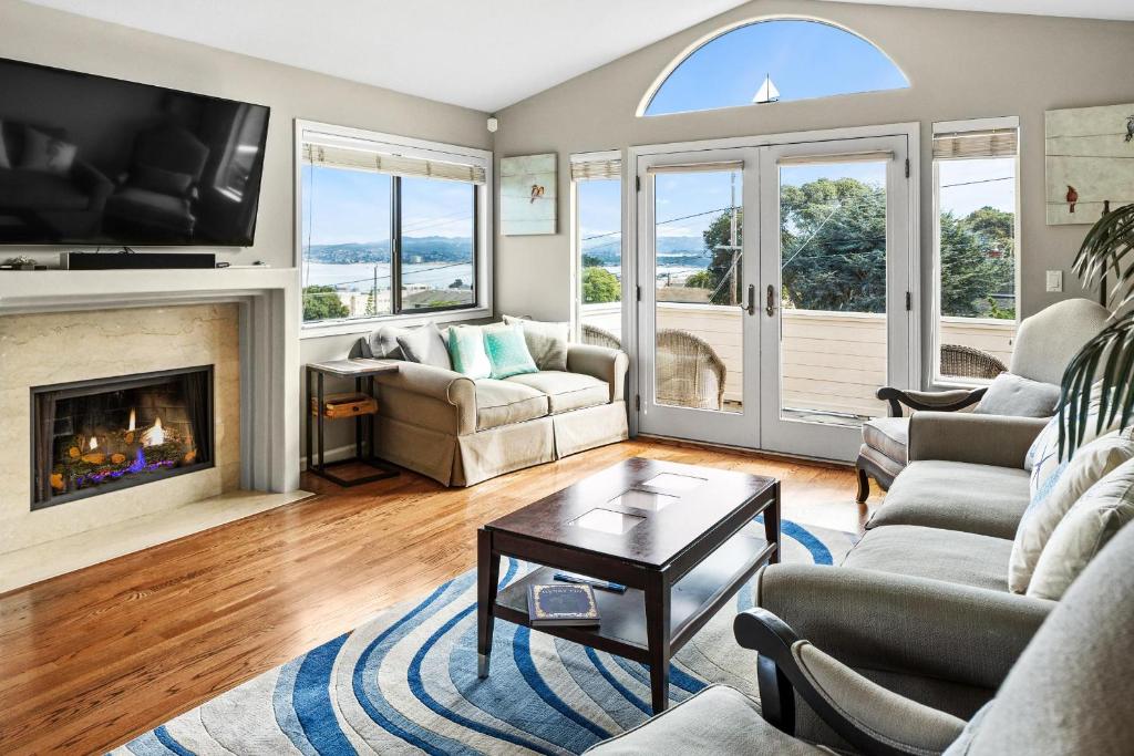 a living room with a fireplace and a tv at Spectacular Views - Walk to Cannery Row and the Aquarium in Pacific Grove
