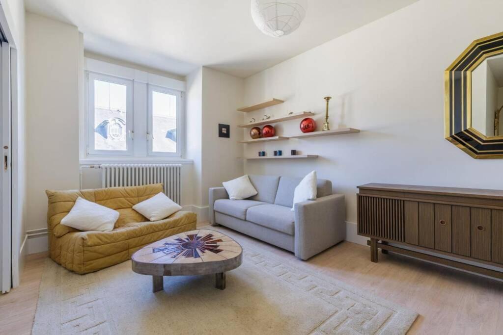 ein Wohnzimmer mit einem Sofa und einem Tisch in der Unterkunft Magnifique appartement au cœur de la Petite France in Straßburg