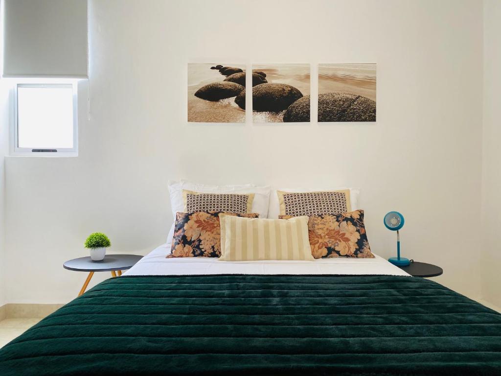 a bedroom with a large bed with a green blanket at Liverté Armonia 102 in Cancún