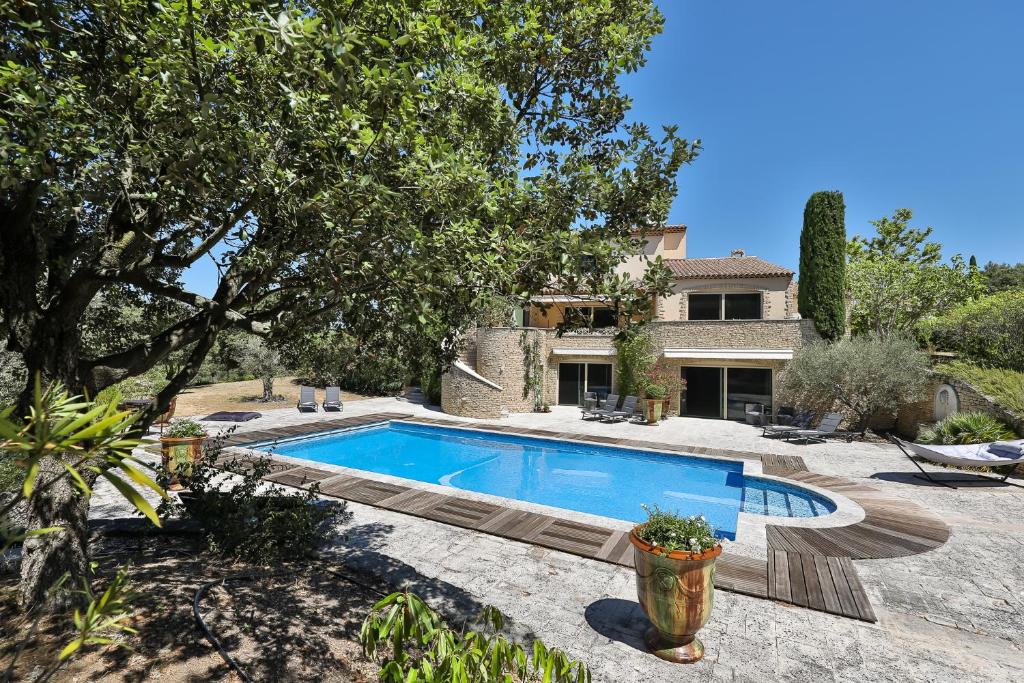 a swimming pool in front of a house at Quintessence Provence in Goult