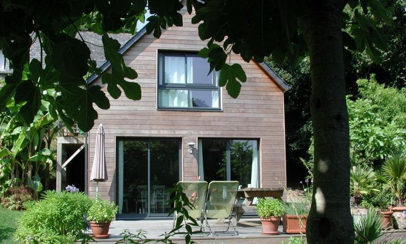 una casa con dos sillas delante en Un Jardin en Pente Douce en Locquénolé
