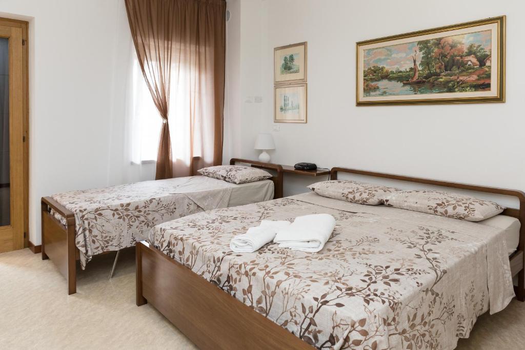 a hotel room with two beds with towels on them at Casa Flora in Treppo Grande