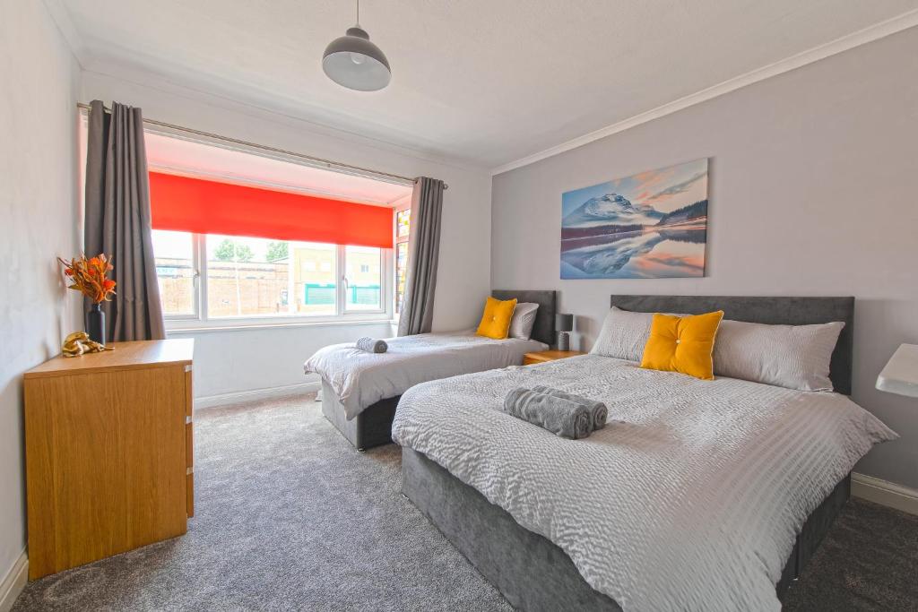 a bedroom with two beds and a window at Bright and Modern Home 4 beds CCTV Parking in Killingbeck