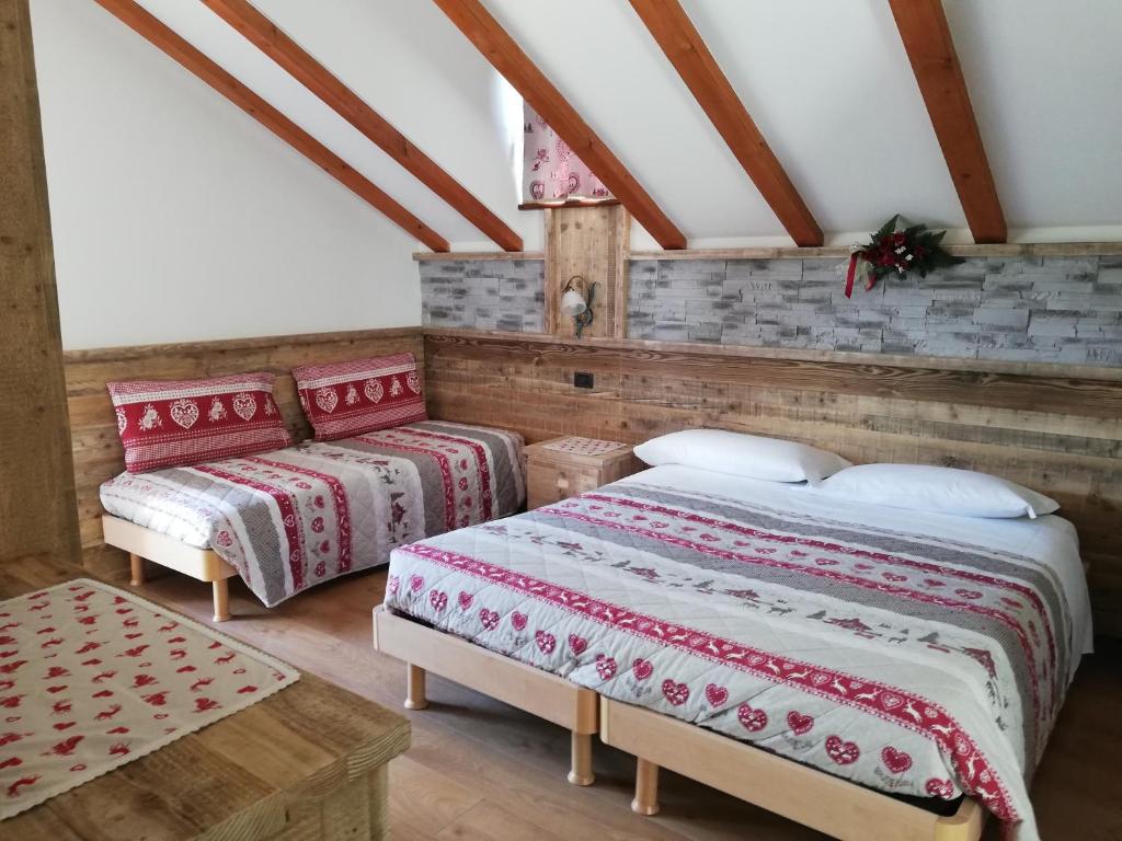 a bedroom with two beds in a attic at Agritur le Vale in Fiera di Primiero
