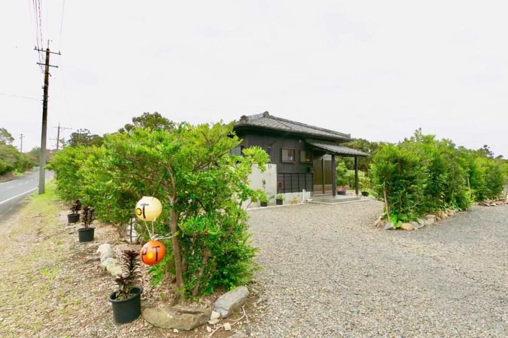 une maison avec une rangée d'arbres à côté d'une route dans l'établissement Kumage-gun - House - Vacation STAY 89468, à Yudomari