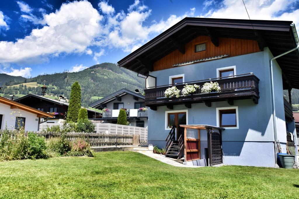 a white house with a balcony with flowers on it at Peters Panoramaappartment in Piesendorf