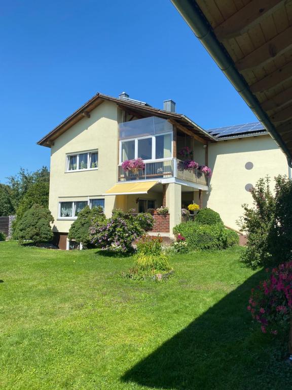 a house with a balcony on a lawn at Luxus FeWo - Spannagl in Pocking