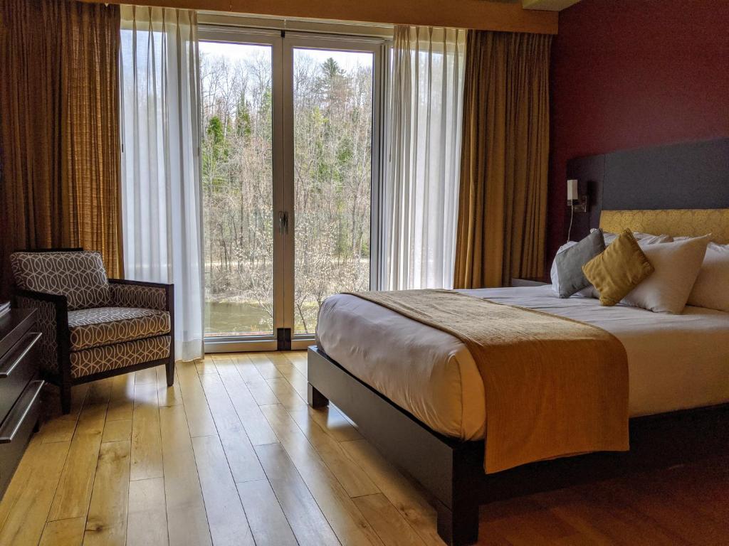 ein Schlafzimmer mit einem Bett, einem Stuhl und einem Fenster in der Unterkunft Moulin Wakefield Mill Hotel & Spa in Wakefield