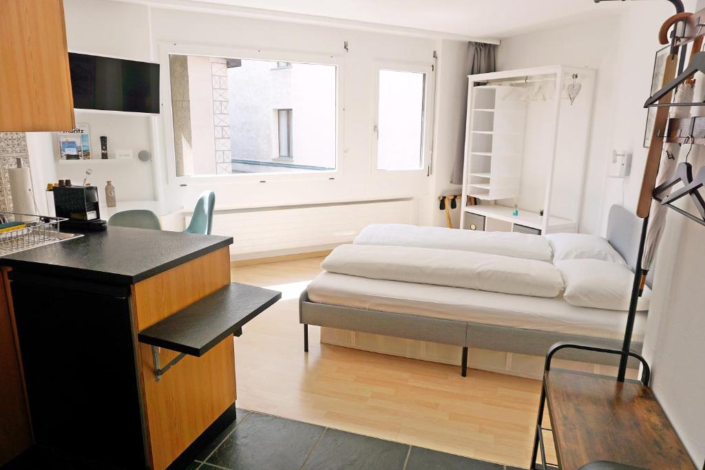 a bedroom with a bed and a desk and a window at Schick und freundlich, zentral, modernes Studio - C5 in St. Moritz