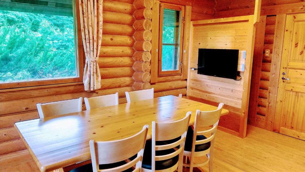 ein Esszimmer mit einem Holztisch und Stühlen in der Unterkunft Maniwa - Cottage - Vacation STAY 90022 in Maniwa