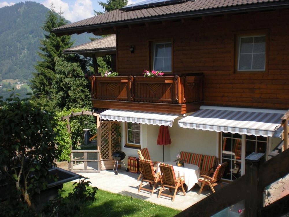 ein Haus mit einer Terrasse mit einem Tisch und Stühlen in der Unterkunft Ferienhaus Deutschmann in St. Johann im Pongau