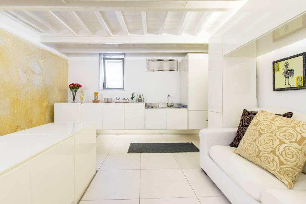 uma sala de estar branca com um sofá e uma cozinha em Campo de' Fiori - Apt 1 em Roma
