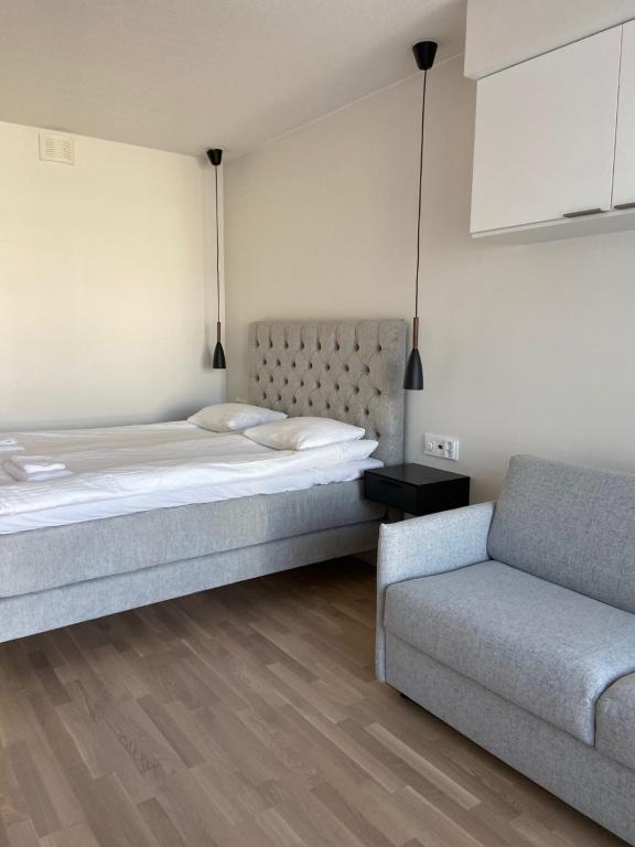 een slaapkamer met een bed en een bank bij Parvekkeellinen yksiö keskustassa in Turku