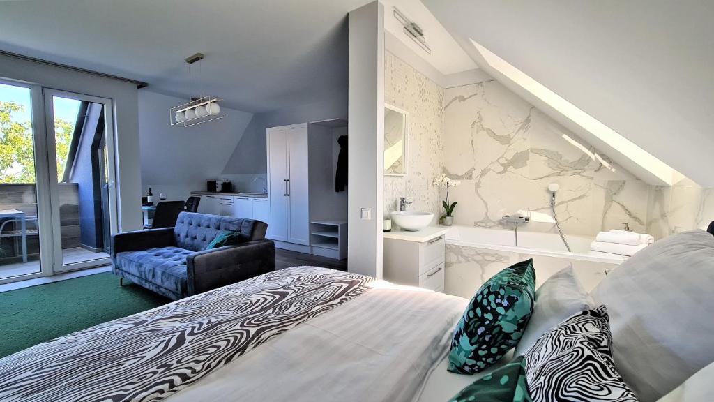 a bedroom with a bed and a chair and a bathroom at Mandula Villa in Tihany
