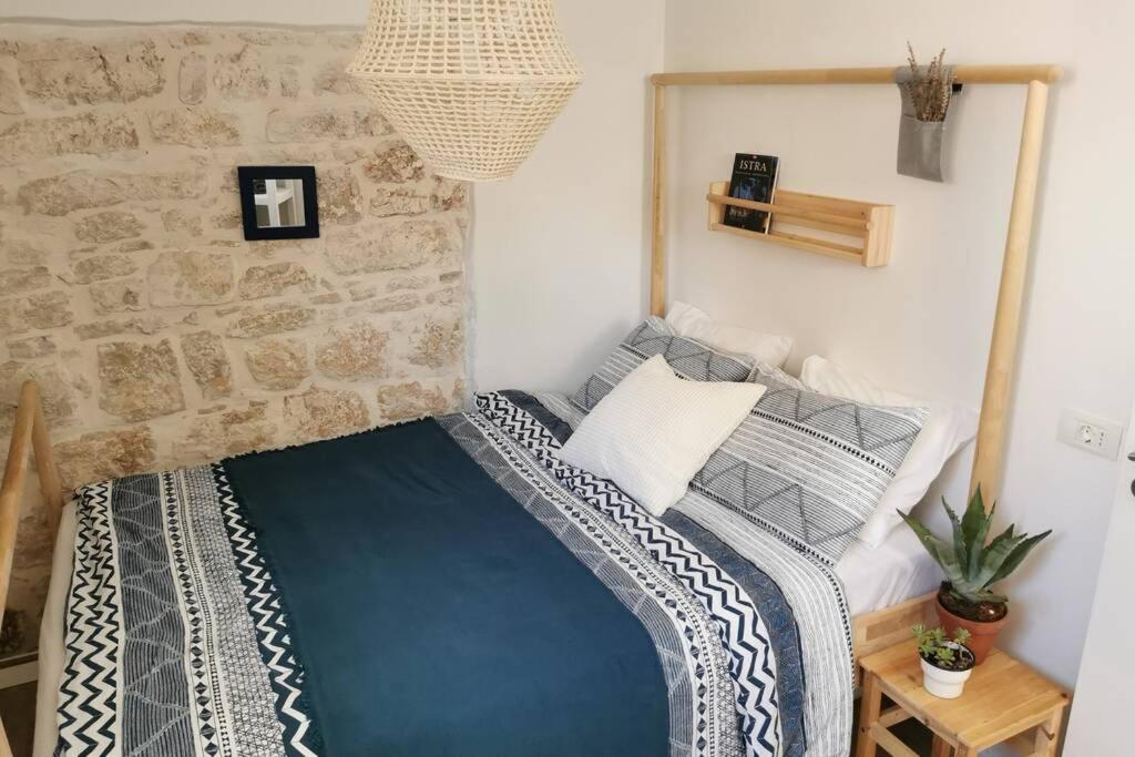 a bed in a room with a stone wall at Casa Porta Verde in Bale