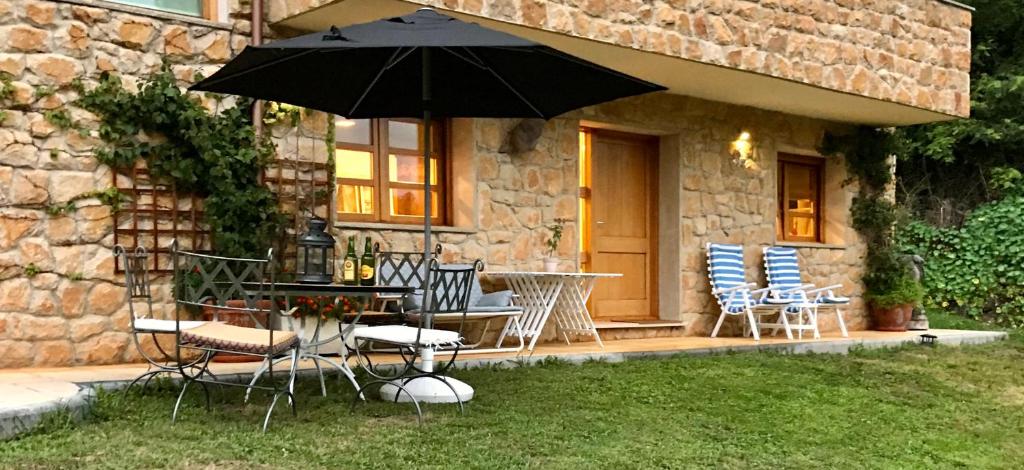 patio con tavolo, sedie e ombrellone di Loft 80 mts en un entorno natural. a Mieres