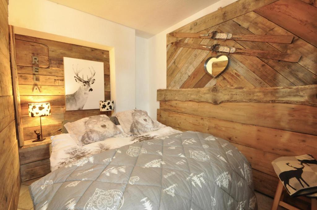 Un dormitorio con una pared de madera y una cama en Magnifica tavernetta di la Thuile en La Thuile
