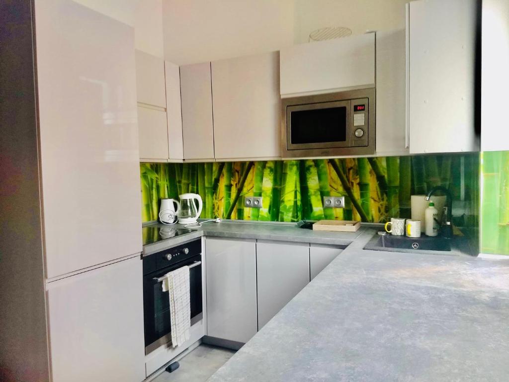 a kitchen with white cabinets and a microwave at VIP Apartments in Krosno Odrzańskie