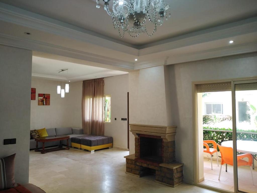 a living room with a couch and a fireplace at Villa à Savannah Beach sidi rahal in Sidi Rahal