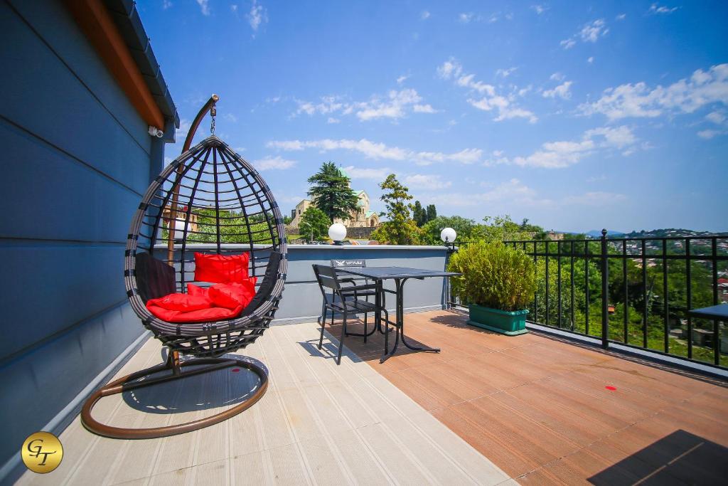a swing sitting on a balcony with a table at Hotel Green Town in Kutaisi