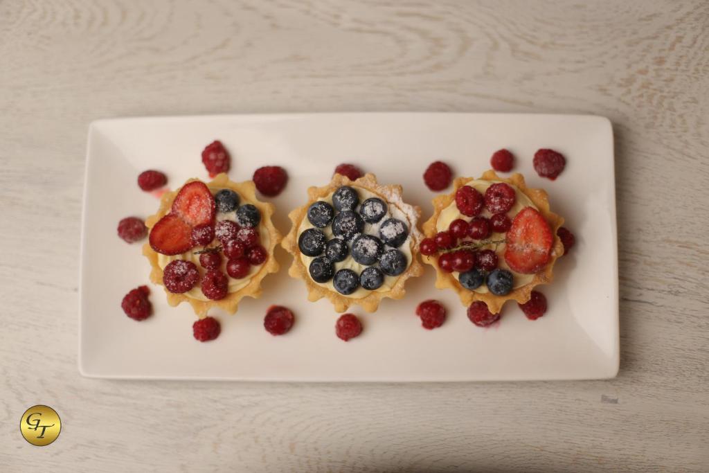 a white plate topped with fruit on top at Hotel Green Town in Kutaisi