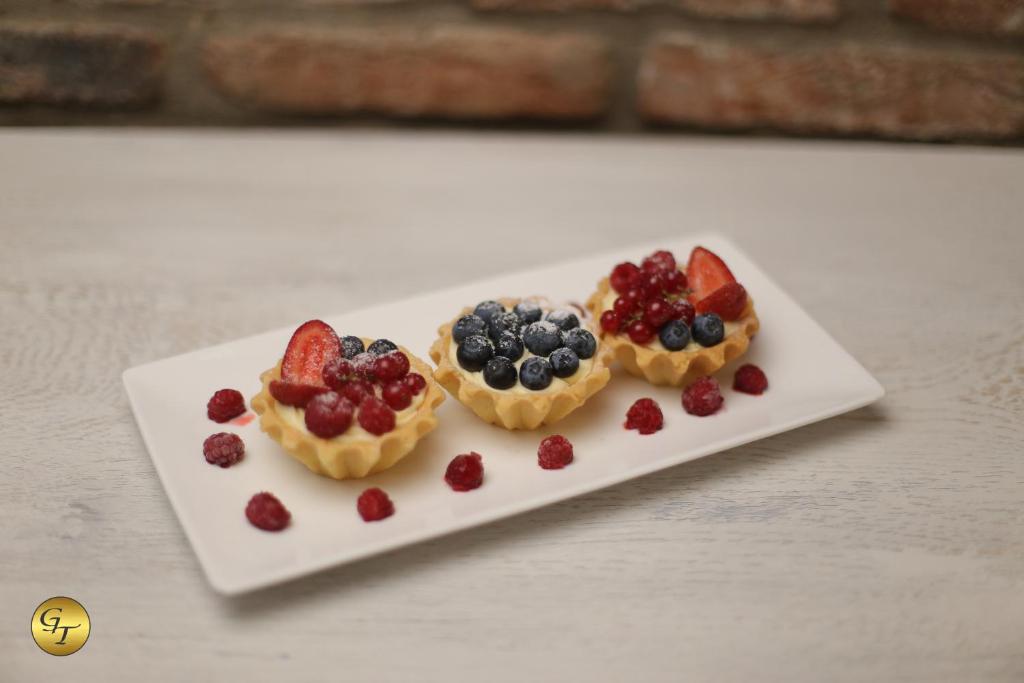 three fruit pastries on a plate on a table at Hotel Green Town in Kutaisi