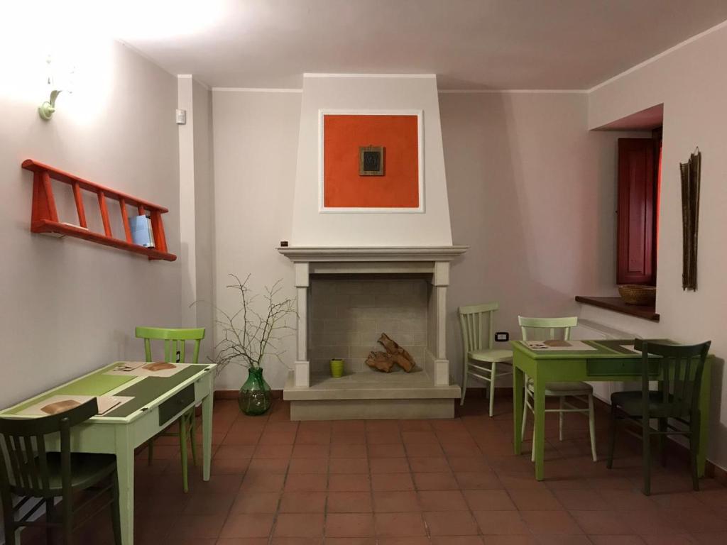 a dining room with green tables and a fireplace at Casa Cuoco in Civita Campomarano