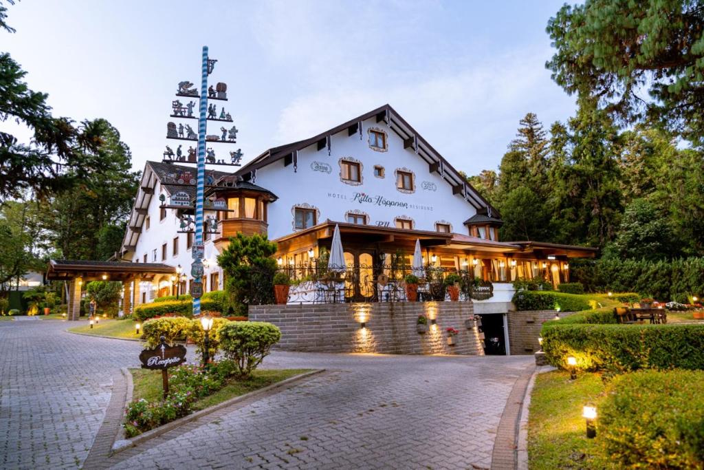 um grande edifício branco com uma torre no topo em Hotel Ritta Höppner em Gramado