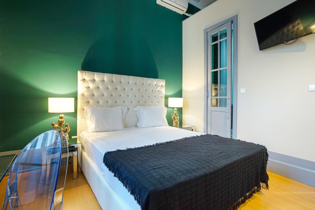 a bedroom with a large bed and a green wall at Patio79 Aveiro in Aveiro