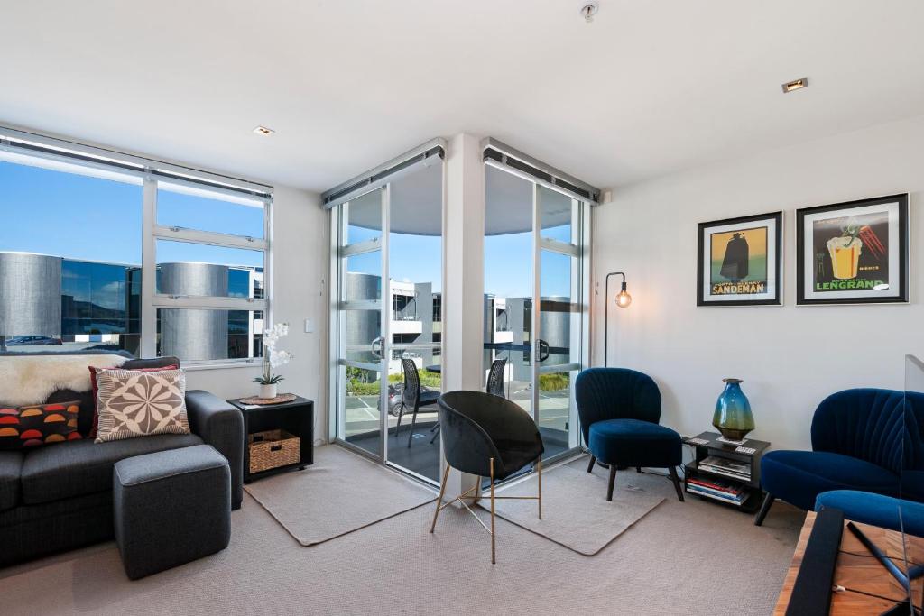 a living room with a couch and chairs at Waimahana Apartment 12 in Taupo