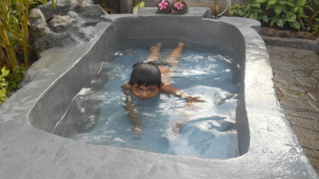 un joven nadando en una bañera de hidromasaje en Taman Menjangan homestay by SnorkelingMenjangan, en Banyuwedang