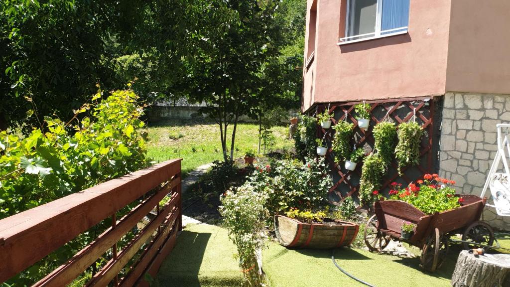 einen Garten mit Blumen und einem Zaun und einem Haus in der Unterkunft Casa Lorena in Sărata-Monteoru