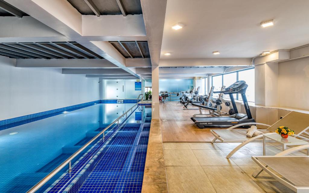 an indoor pool with a gym with treadmills at Cherry Hotel and Apartment in Ho Chi Minh City