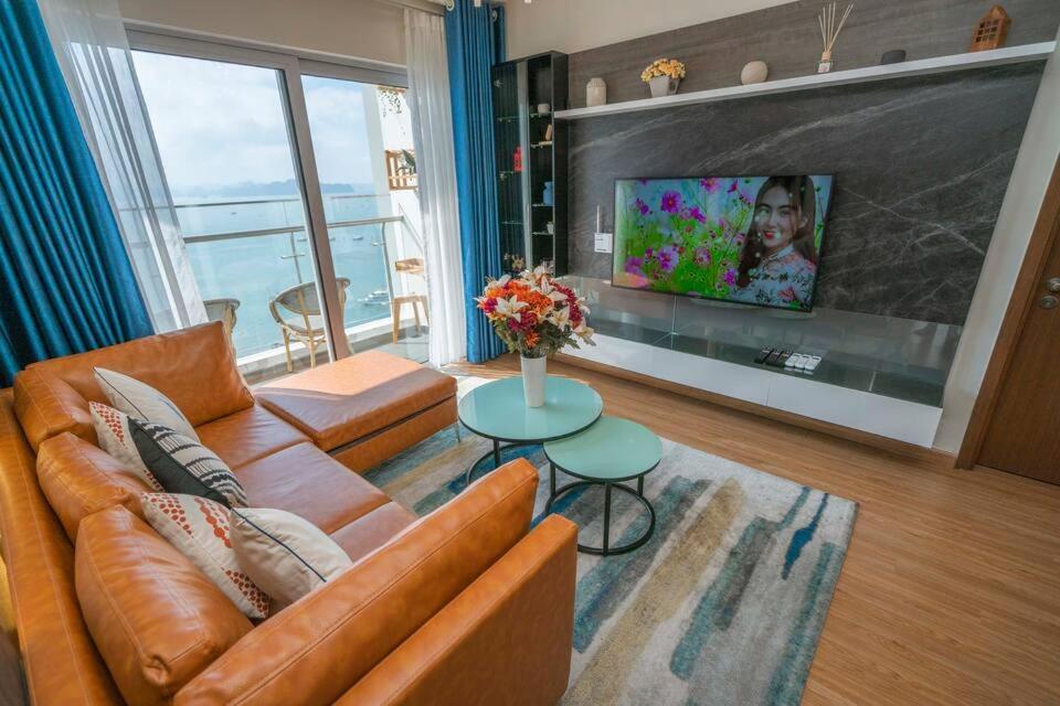 sala de estar con sofá y TV de pantalla plana en BOM HOMES- THE SAPPHIRE HA LONG RESIDENCE APARTMENt, en Ha Long