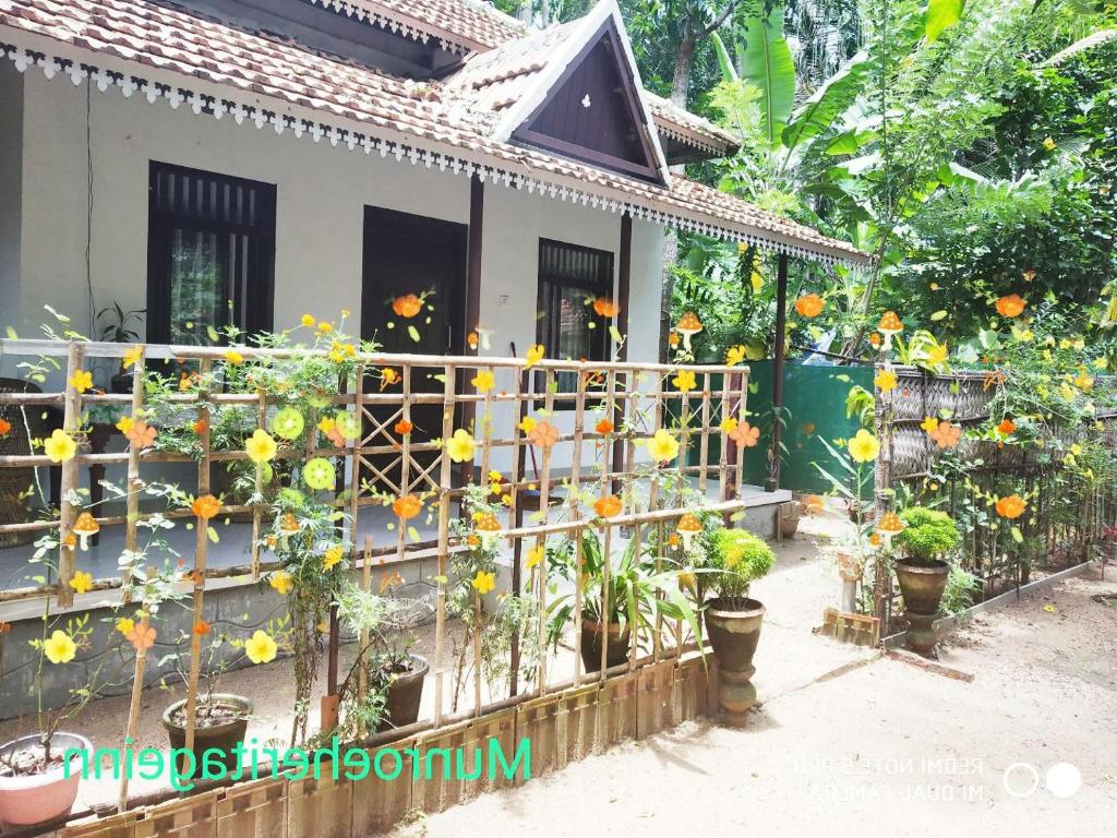 una casa con fiori su una recinzione di Munroe Heritage Inn a Munroe Island