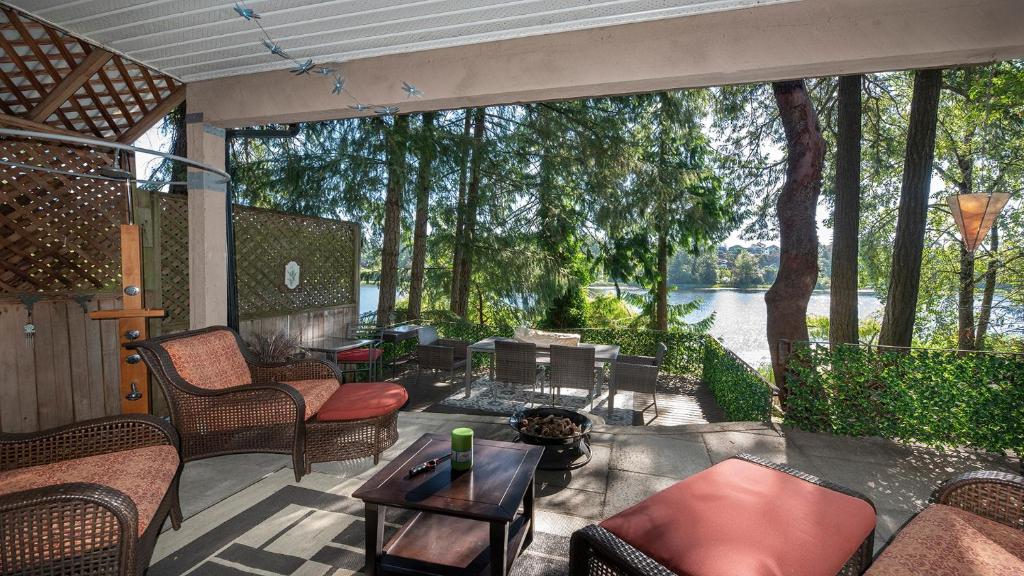 un patio con muebles y vistas al agua en Willow Suite - Lakeside Retreat, en Victoria