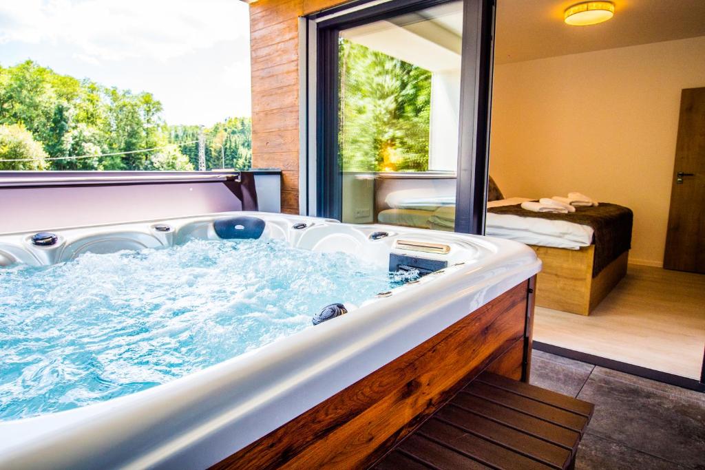 eine große Badewanne in einem Zimmer mit Fenster in der Unterkunft Penthouse apartments in Trstená