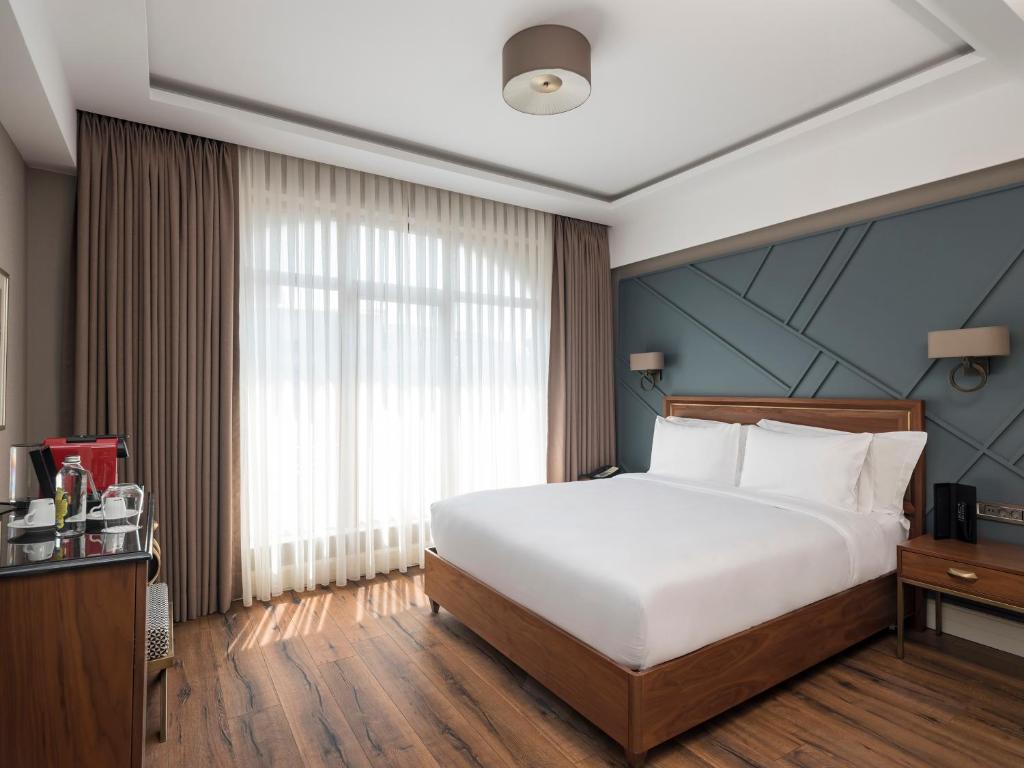 a bedroom with a large bed and a large window at Azzap Hotel Galata in Istanbul