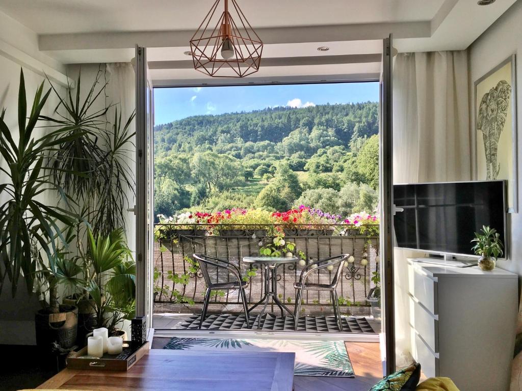 a living room with a balcony with a table and chairs at Apartament Dobre Miejsce in Ustrzyki Dolne