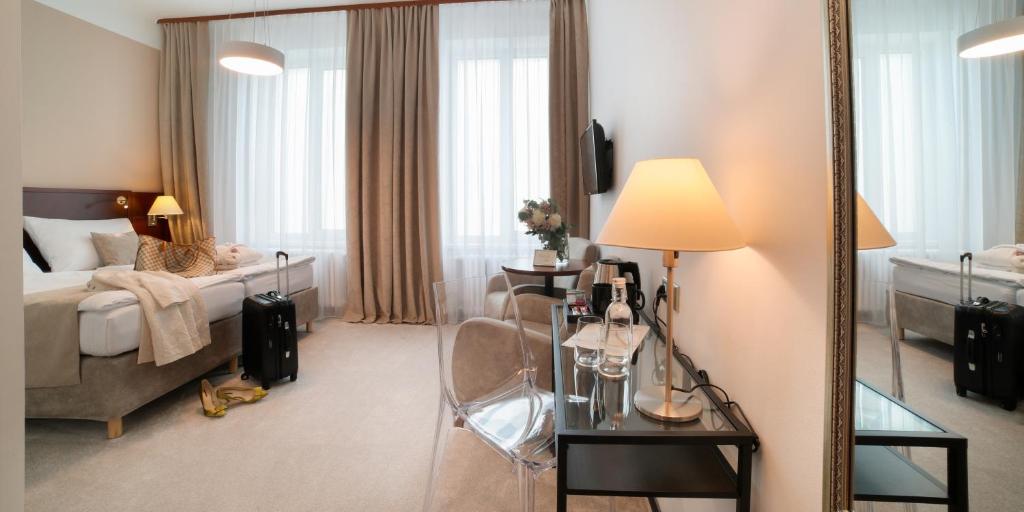 ein Hotelzimmer mit einem Bett und einem Spiegel in der Unterkunft Hotel KOZÁK in Brünn