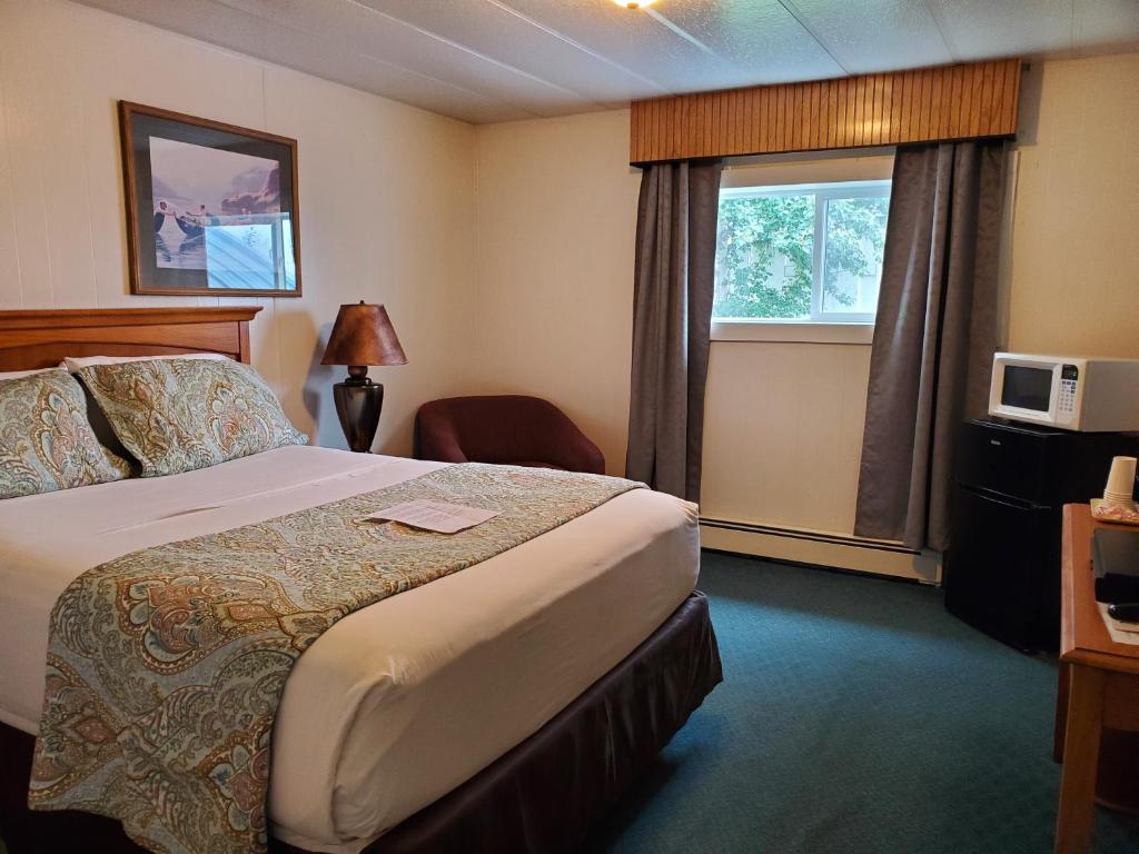 Delta JunctionにあるAlaska Country Innのベッドと窓が備わるホテルルーム