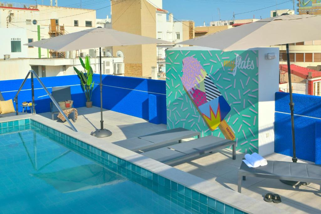 una piscina con mesa, sombrilla y sillas en MyFlats Luxury Downtown, en Alicante