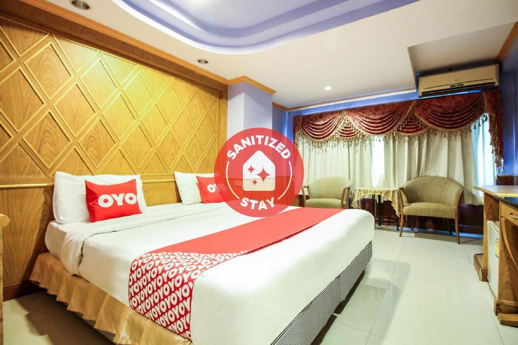 una camera d'albergo con un letto con un cartello rosso sopra di OYO 280 Thai Garden Resort a Bangkok