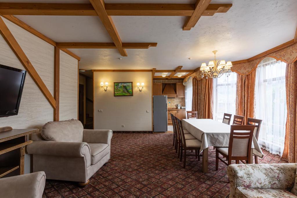 a living room with a dining room table and chairs at Bukovel Hotel in Bukovel