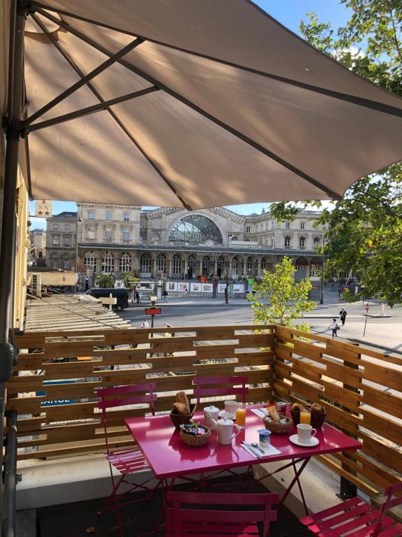 a patio with two tables and chairs and a building at Hotel Little Regina in Paris
